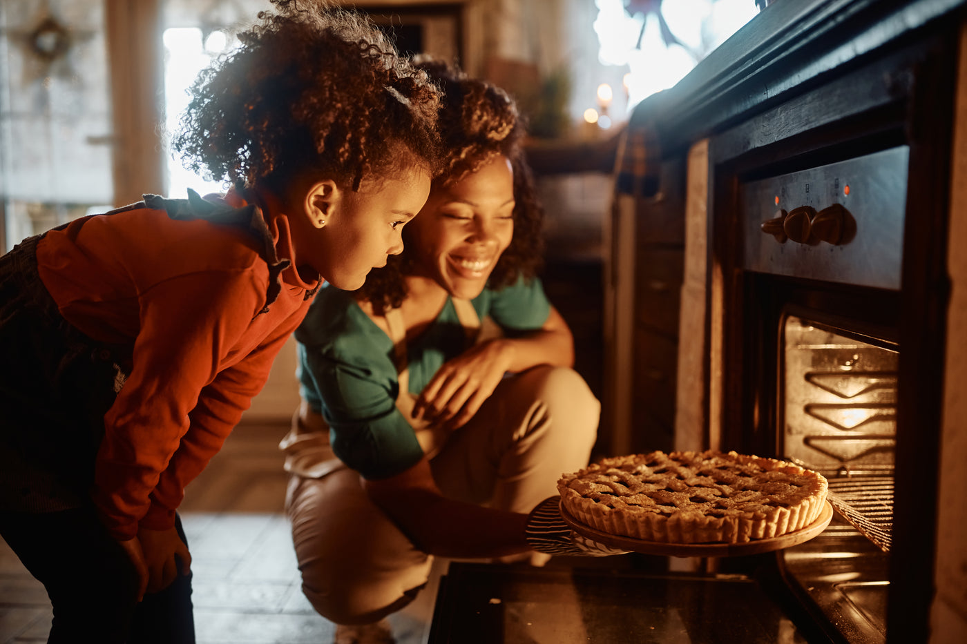 Quality family time as food comes out of a oven appliance.